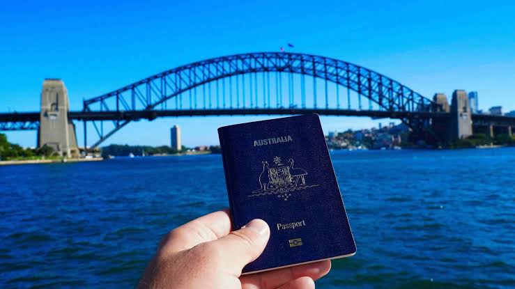 Australian passport held in front of Sydney Harbour Bridge